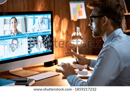 Businessman executive leading virtual team meeting on video conference call using computer working from home office talking to diverse colleagues in remote videoconference online social distance chat. Royalty-Free Stock Photo #1859217232