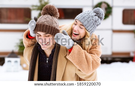 Young Couple In Love Having Fun Outdoors At Winter Day, Romantic Man And Woman In Woolen Hats Playing And Laughing Together, Enjoying Spending Christmas Holidays In Camping, Closeup Shot