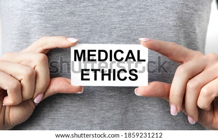 The girl holds a card with medical ETHICS .
