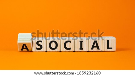 Social or asocial. Fliped wooden cubes and changed the word 'asocial' to 'social' or vice versa. Beautiful orange background, copy space. Business and asocial or social concept.