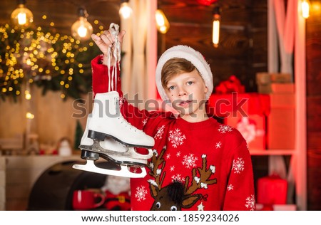 Christmas coming. Christmas mood concept. Santa claus kid. Transform your shoes into ice skates for Winter. New year party. Happy winter holidays. Small boy. Little boy child in santa red hat.