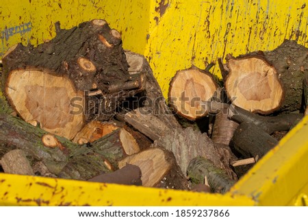 A yellow skip, container is loaded with rubble and wood. Royalty-Free Stock Photo #1859237866