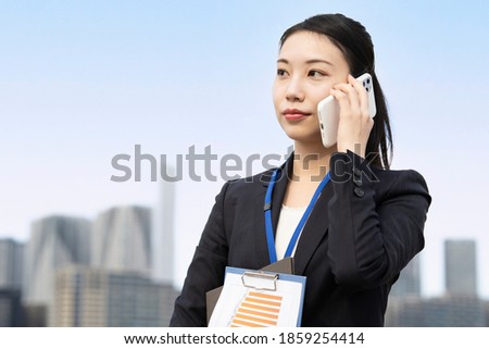 A business woman who talks with her smartphone on her ear