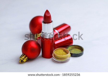 Red lipstick and christmas toys on light background. Christmas sale concept