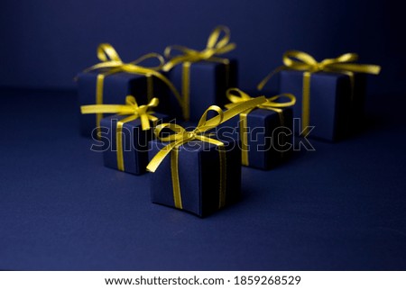 Navy blue gifts with gold ribbons.Set of gift box isolated on navy blue background.Christmas gift boxes on black background. Merry Christmas and Happy Holidays greeting card, frame, banner. 