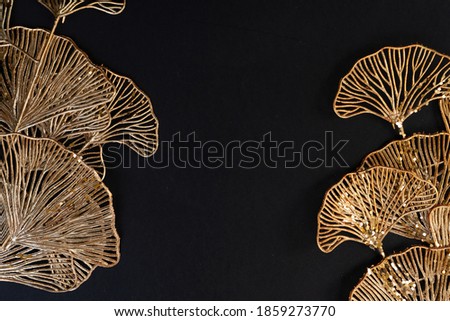 Golden tropical flowers frame on black background, art deco style, top view