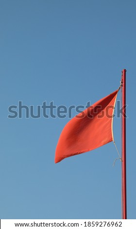 red flag waving to indicate danger with the background of blue sky and no people Royalty-Free Stock Photo #1859276962