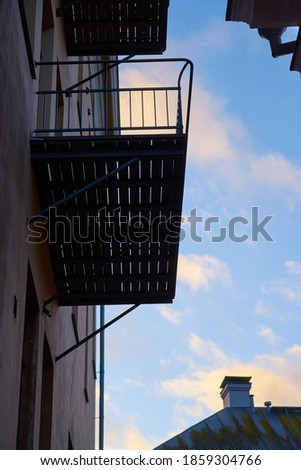 The walls of old houses with balconies and blue sky in the background.