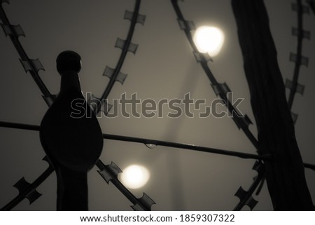 Abstract picture of wire fence and lights at the background