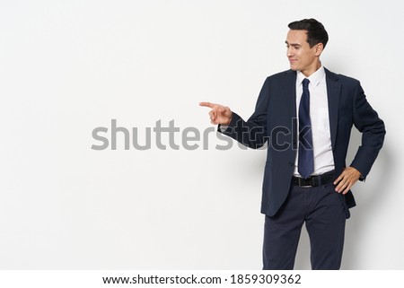 Business man in a suit tie self-confidence shows a finger to the side 