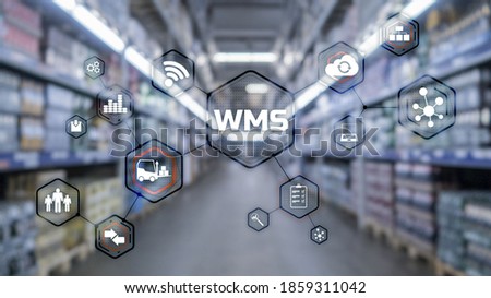 Inscription WMS on blurred warehouse background. Werehouse Management System. Royalty-Free Stock Photo #1859311042