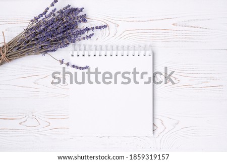 Composition from blank diary, lavender flowers on a white shabby wooden table. Fashion flat lay