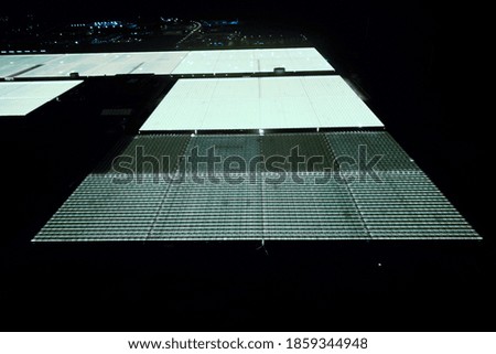 greenhouse glows bright yellow at night, aerial photography