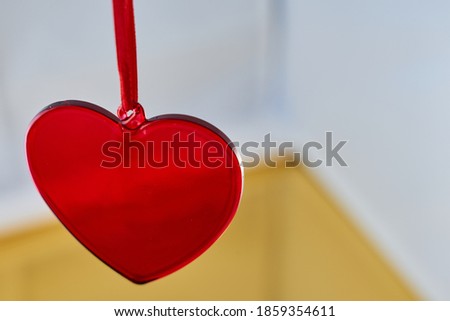 A red glass heart with a blurred background.