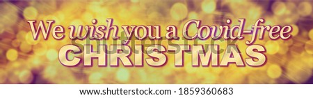 Bah Covid Concept Background – hands holding a white placard with the words BAH COVID against a graduated Christmas tinsel background with copyspace 

