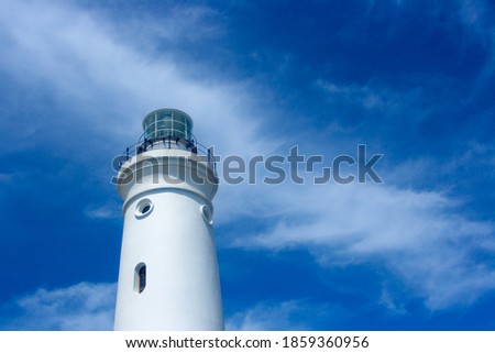 White Lighthouse Tower With Cloudy Blue Sky