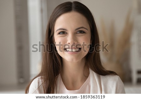 Headshot portrait profile picture of pretty smiling young woman posing indoors looking at camera, satisfied female customer client leaving video comment feedback of consumer goods or service purchased
