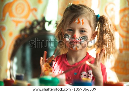 Child, little girl drawing paint with paint of face.