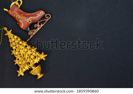 gold shiny christmas toy shape  skates and christmas tree decoration isolated on a black background