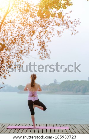 woman practicing yoga at seashore