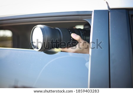 A man taking a picture from inside the car