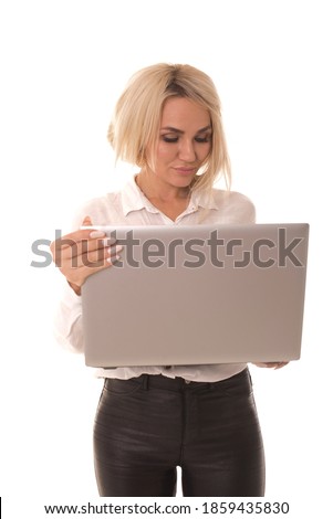 Blonde stands on a white background with a laptop in her hands. Girl stands on a white background with a laptop in her hands. 