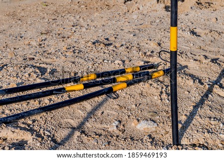 Metal black and yellow marker poles at local construction site.