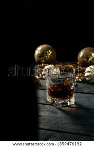 Still life of alcoholic christmas drink. Glass of whiskey on dark wooden table