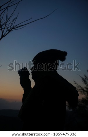 Silhouette of a person drinking coffee in the morning