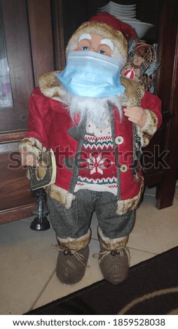 santa claus decorative doll wearing surgical mask during coronavirus, covid-19 pandemy outbreake lockdown and quarantine Before christmas and new year 2021 holidays