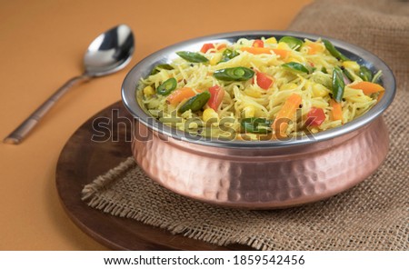 Semiya Upma or Vermicelli Uppuma or uppittu is a popular breakfast menu from south India. served in a bowl on wooden plate. selective focus Royalty-Free Stock Photo #1859542456