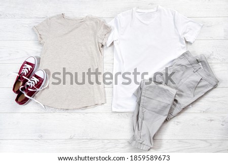 Male and female T shirt white and sneakers. T-shirt Mockup flat lay with summer accessories. Outfit for women and men on wooden floor background. Copy space. Template blank canvas.