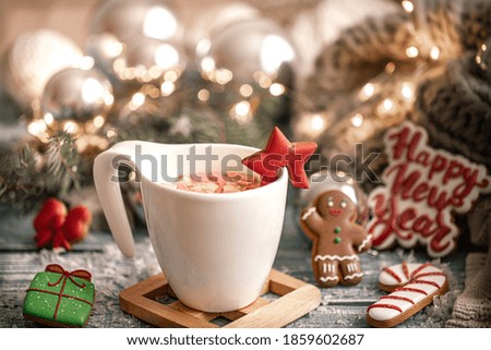 Cup with a hot drink, marshmallow on a table with Christmas decorations on background with gingerbread cookies. New year drinks advertising concept.