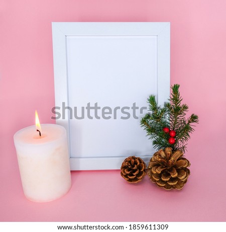 Frame and christmas decoration on a pink background.
