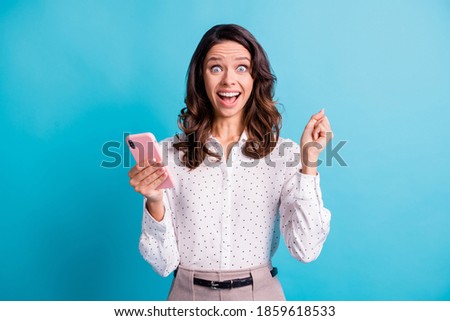 Photo of impressed hooray brunette girl hold telephone wear shirt isolated on teal color background
