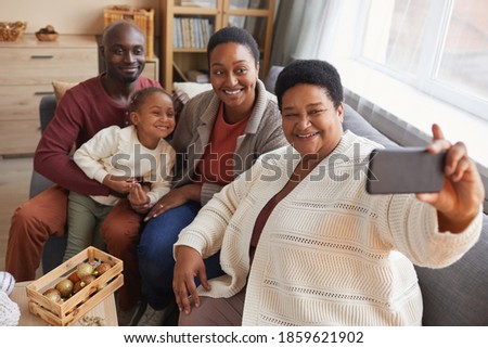 High angle portrait of big happy African-American family taking selfie photo while enjoying Christmas at home together