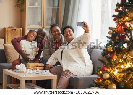 Portrait of big happy African-American family taking selfie photo while enjoying Christmas at home together