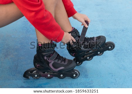 Woman seated tying the laces of roller skates before roller skating.Sport active lifestyle background concept.