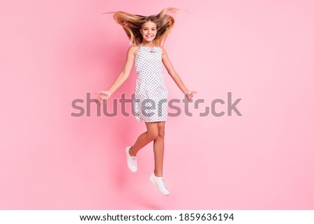 Full size photo of cute blond girl jumping wear white dress isolated on pastel pink color background
