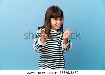 Little girl over isolated background applauding after presentation in a conference
