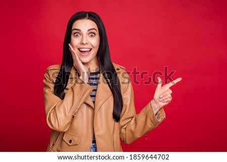 Photo of impressed pretty person arm on cheek open mouth direct finger empty space offer isolated on red color background