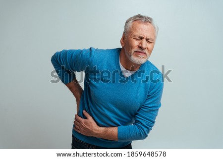 Handsome senior  isolated on grey background. Old man feeling pain. Concept about the third age and seniority Royalty-Free Stock Photo #1859648578