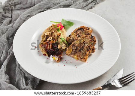Pate with Dried Fruits and Nuts Bread. Gray table with textile and kitchenware. Rustic food style