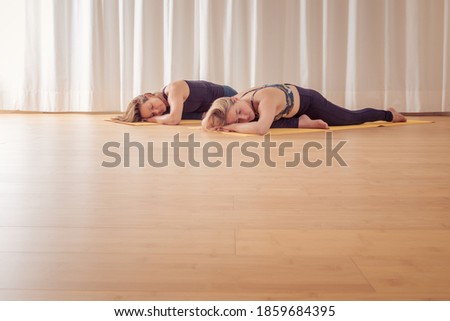 An image of two women doing yoga at home