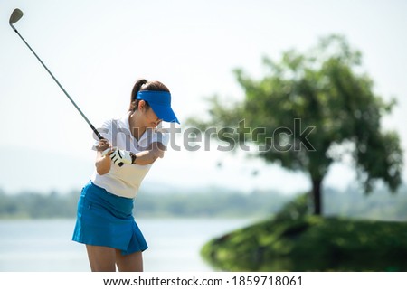 Healthy Sport. Asia golf woman golfer player chips and swing golf on the green Floating water.  people golf presumably does exercise and hobby in holiday. Healthy Lifestyle Concept.