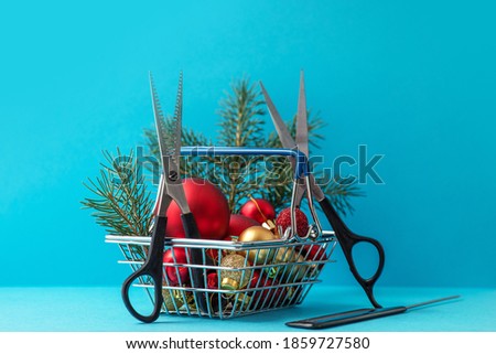 Christmas composition. Hairdressing scissors and a spruce branch in a basket with Christmas decorations on a blue background. Template for a postcard or information about a hair salon. copy space.