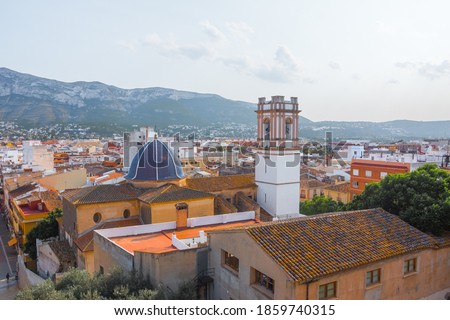 Beautiful cityscape of Denia and its Isglesia de la asunción. Aerial view from the historic moorish castle in the old town that holds the Palau del Governador. Valencian Community, Spain.