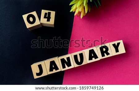 January 4 on wooden cubes on a black and pink background.Beginning of year .Calendar for January.