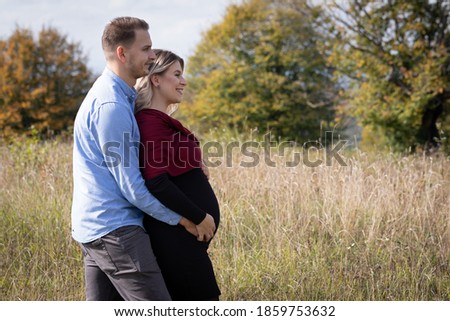 Happy couple waiting for childbirth making memories outdoor. Pregnancy photo shooting