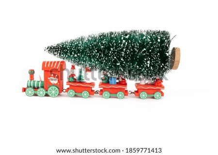 Red train toy carry on the Christmas tree on white background for creative graphic design such as new year card, note book cover, digital card and